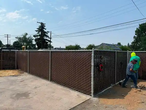 L S Fencing crew member standing at a brown Viewguard gate