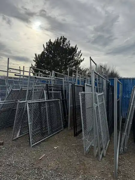 Chain-link gate panels stacked upright in the L S Fencing yard